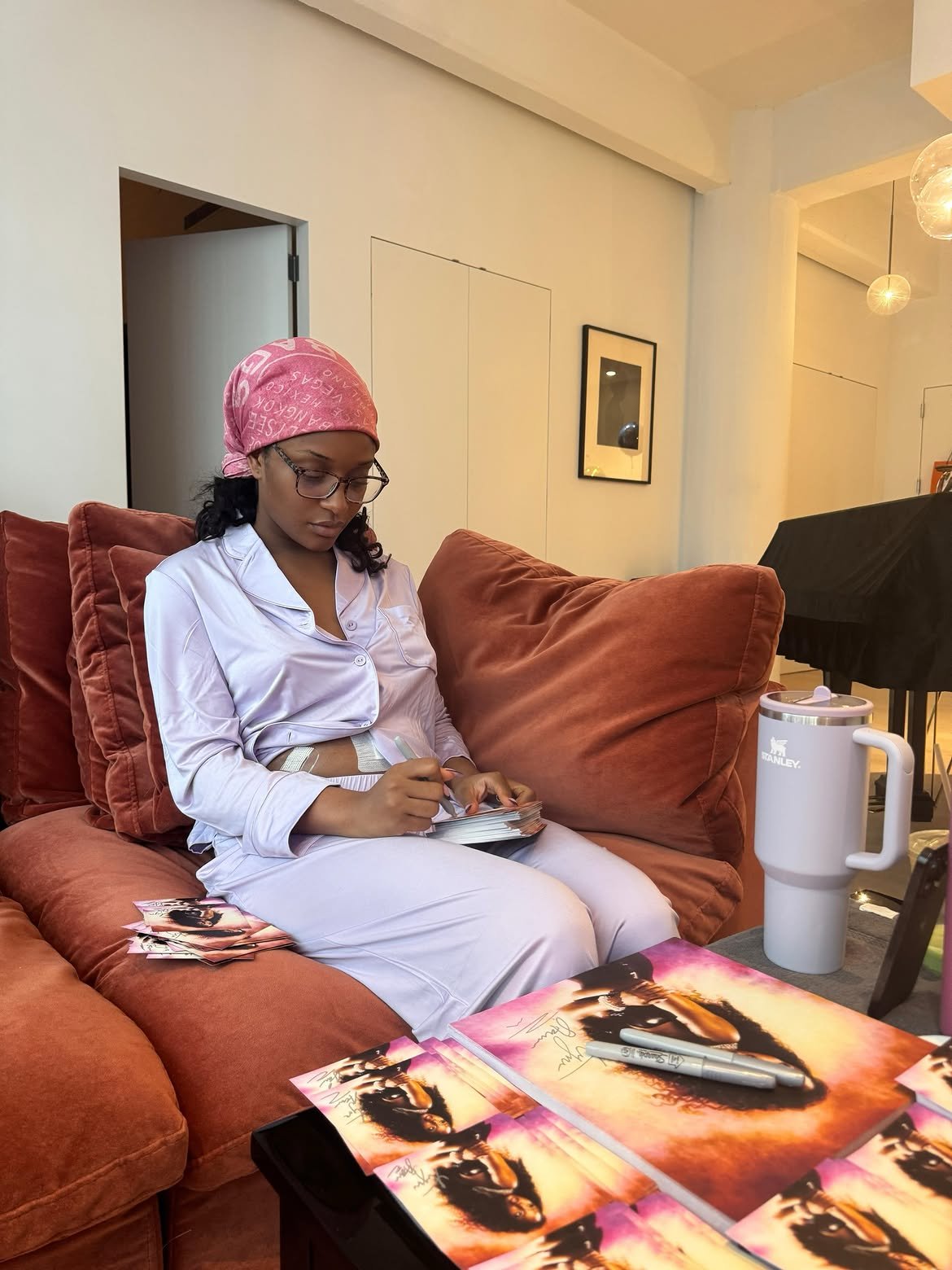 Ayra Starr signs Starrgirl album inserts while recovering from major surgery.